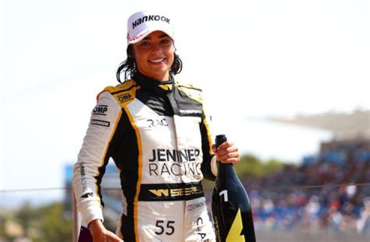 Jamie Chadwick in Workout Gear Says "Train, Race, Repeat"